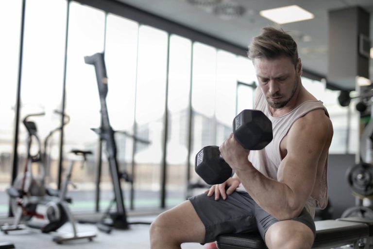 a-man-sitting-on-a-gym-bench